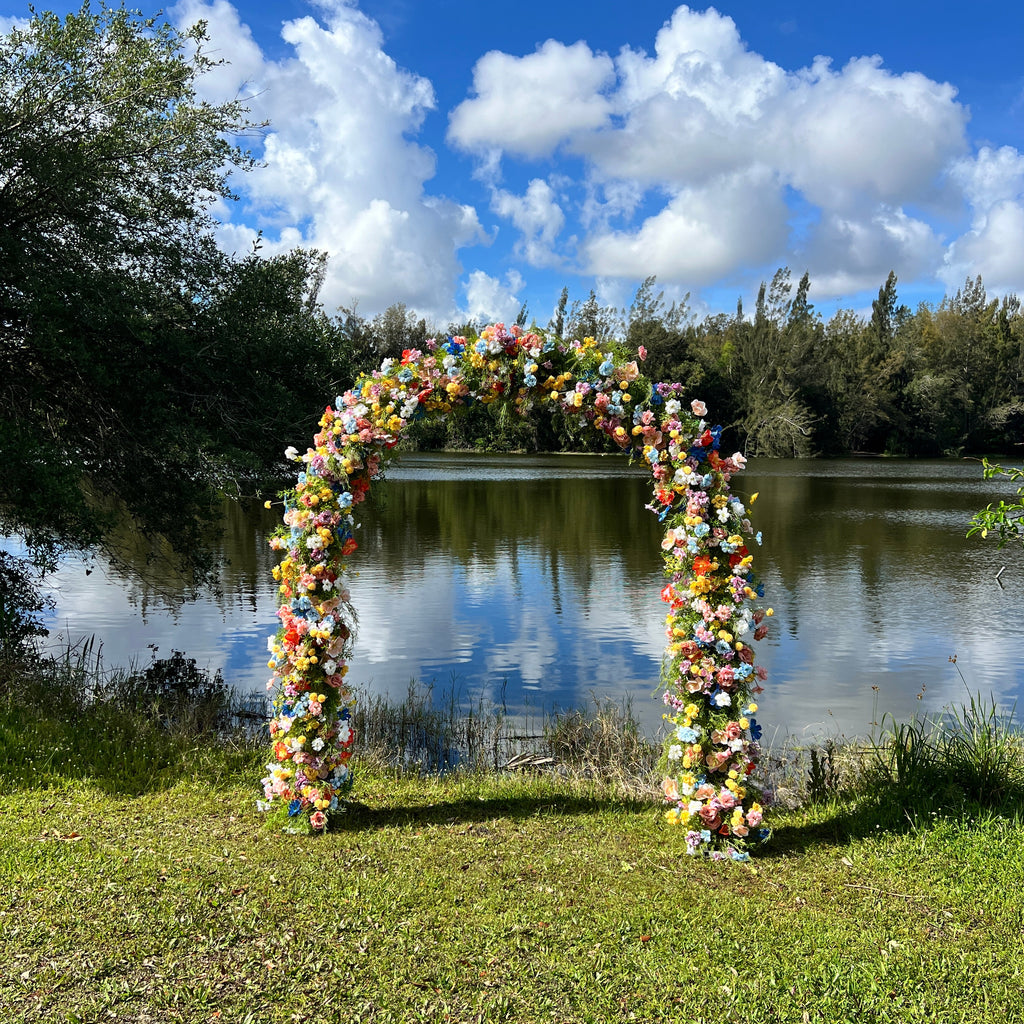 Colorful flower wreath on a wall with a blue sky and clouds in the background