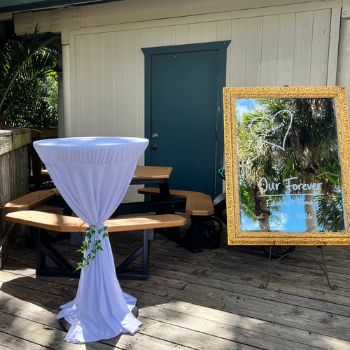 Decorative tablecloth on a wooden table with a mirror reading 'Our Forever' on a wooden deck.